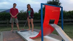 Zwei Jugendliche spielen Minigolf.