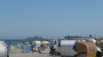 Strand mit Strandkörben vor dem Meer.